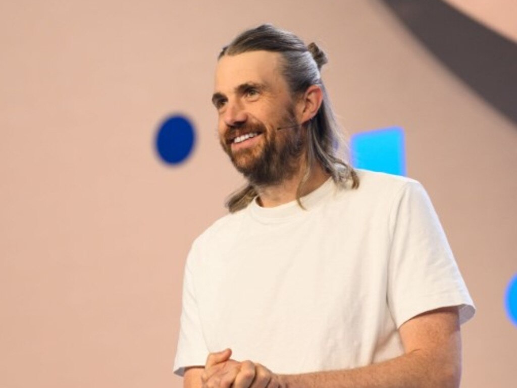 Mike Cannon-Brookes ยิ้มขณะให้สัมภาษณ์บนเวที